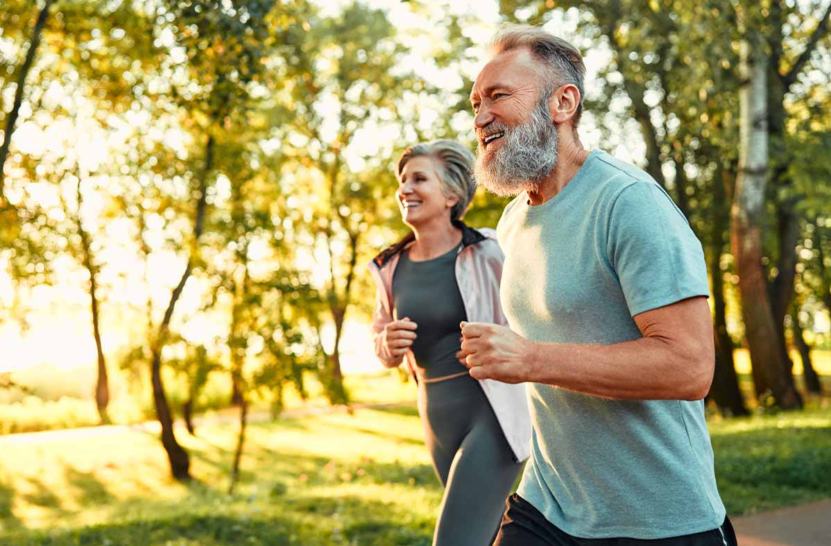 husband and wife jogging in woods